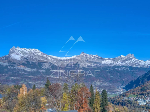 View of the mountains with snow-capped peaks and trees in autumn at Combloux.