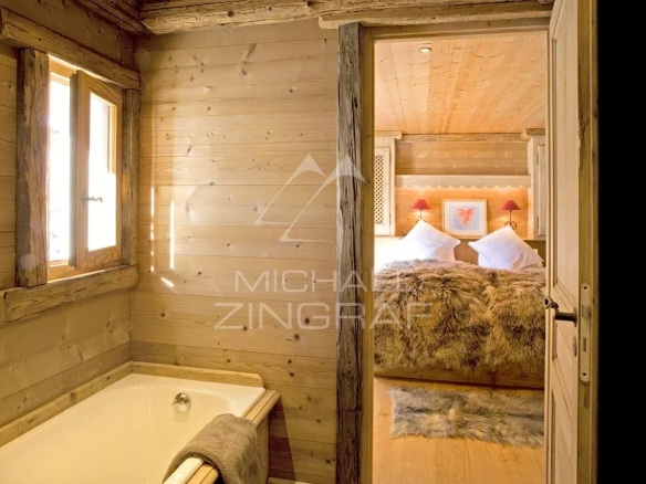 Salle de bain avec baignoire et chambre à coucher dans un chalet en bois