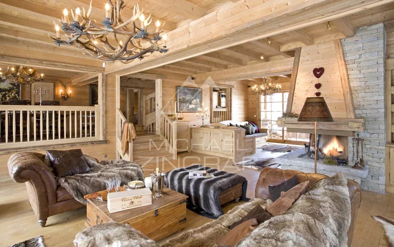 Intérieur d'un chalet en bois avec salon et cheminée, décoré dans un style montagnard.