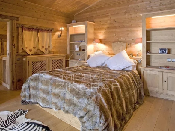 Chambre d'un chalet en bois avec lit en fourrure et décoration en bois
