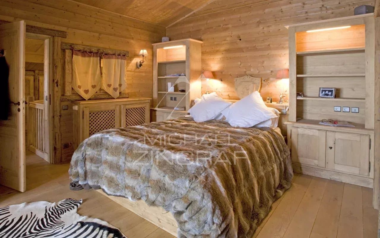 Chambre d'un chalet en bois avec lit en fourrure et décoration en bois