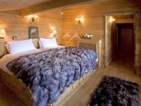 Chambre d'un chalet en bois avec lit double et décoration en bois, Megève