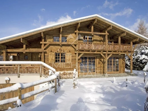 Chalet en bois authentique avec balcon, entouré de neige, à Megève.