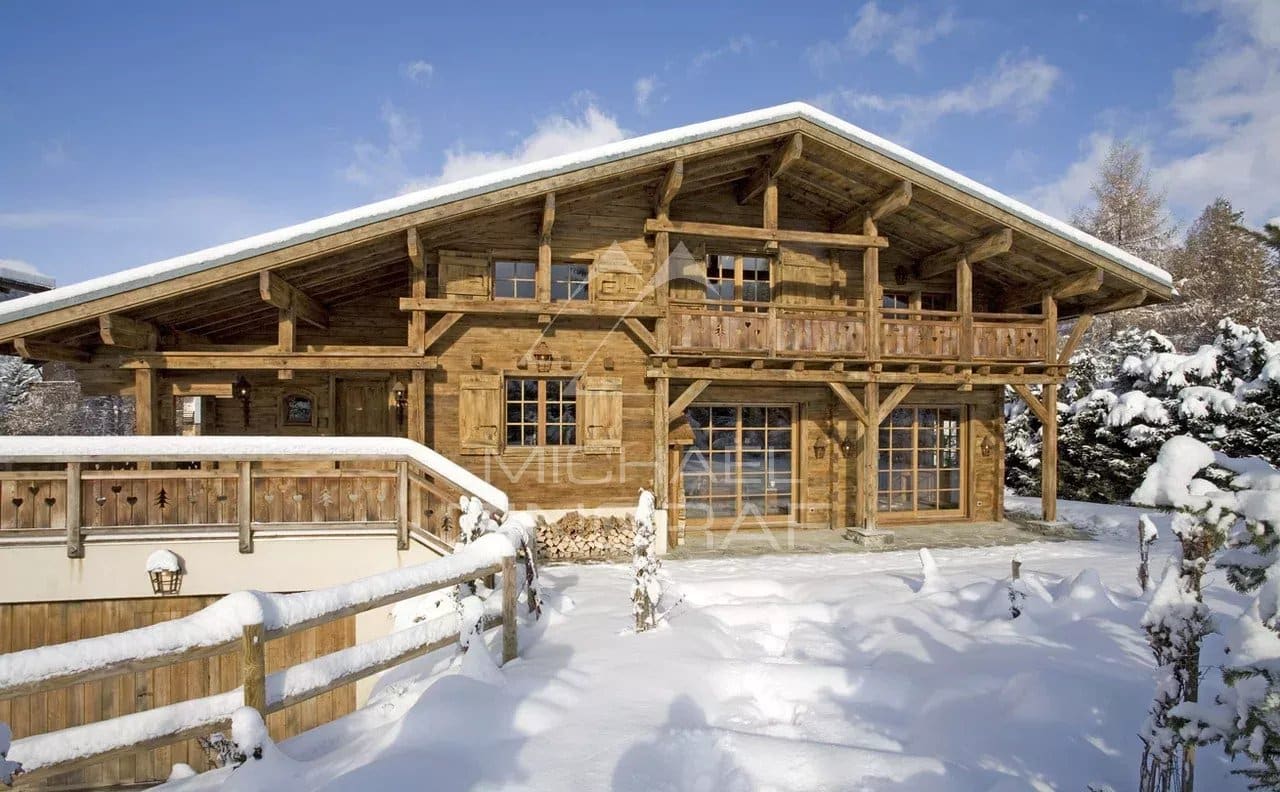 Chalet en bois authentique avec balcon, entouré de neige, à Megève.