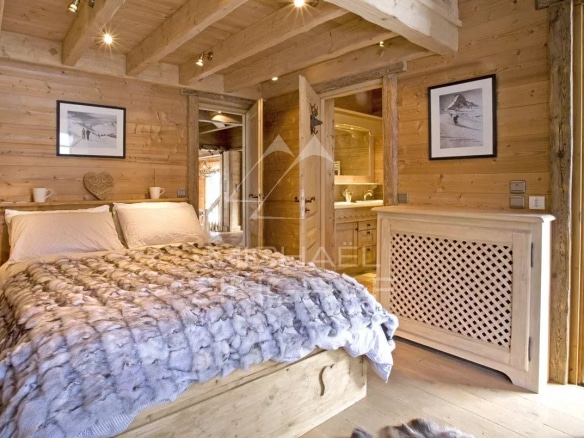 Chambre d'un chalet en bois avec lit et décoration en bois, ambiance chaleureuse.