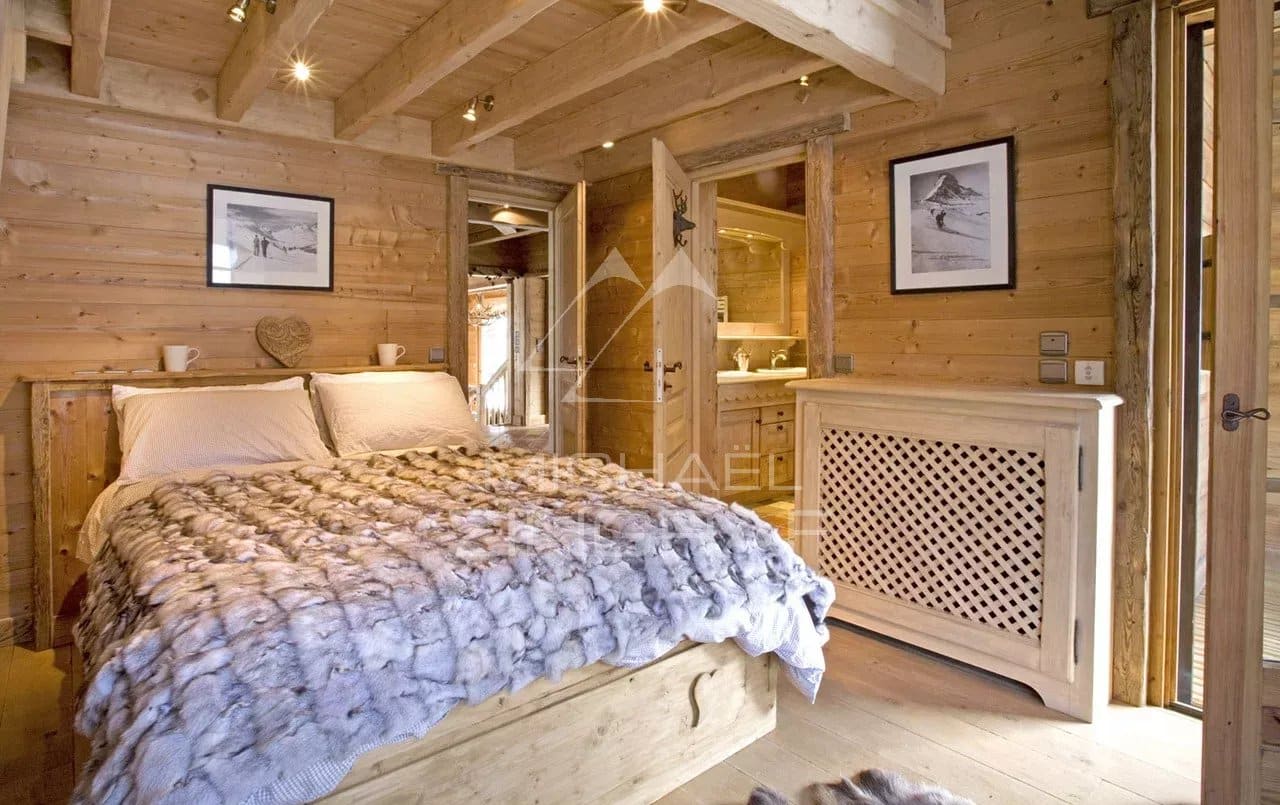 Chambre d'un chalet en bois avec lit et décoration en bois, ambiance chaleureuse.