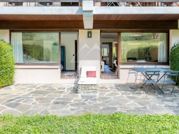 Terrasse d'un appartement rénové avec vue sur le jardin à Megève, avec mobilier d'extérieur.