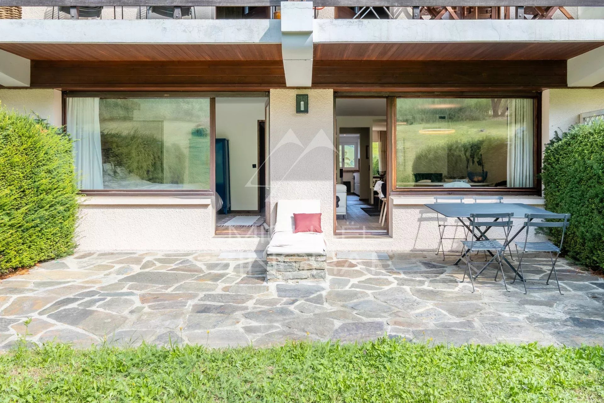 Terrasse d'un appartement rénové avec vue sur le jardin à Megève, avec mobilier d'extérieur.