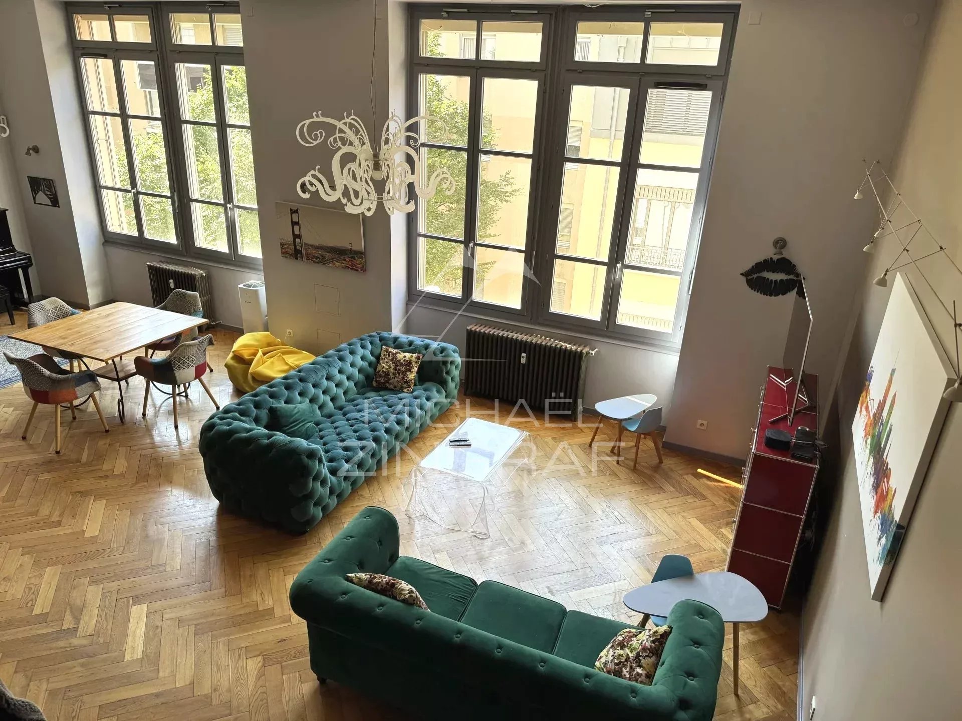 Interior of a renovated loft in Lyon 6th district with a bright living room and modern furniture.