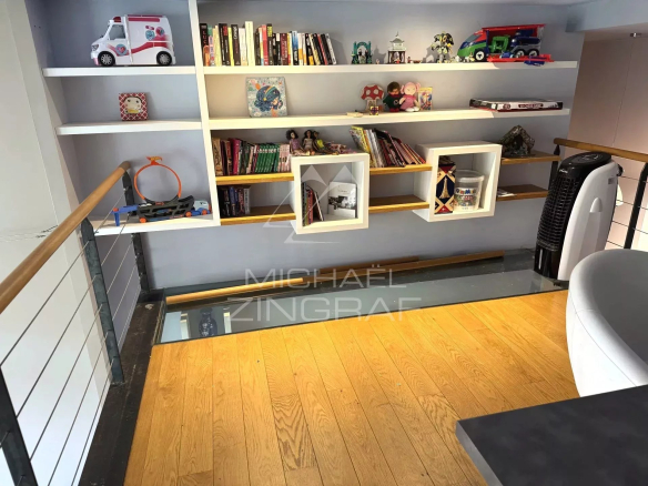 Interior of a renovated family loft with library and bright living space in Lyon 6th arrondissement.
