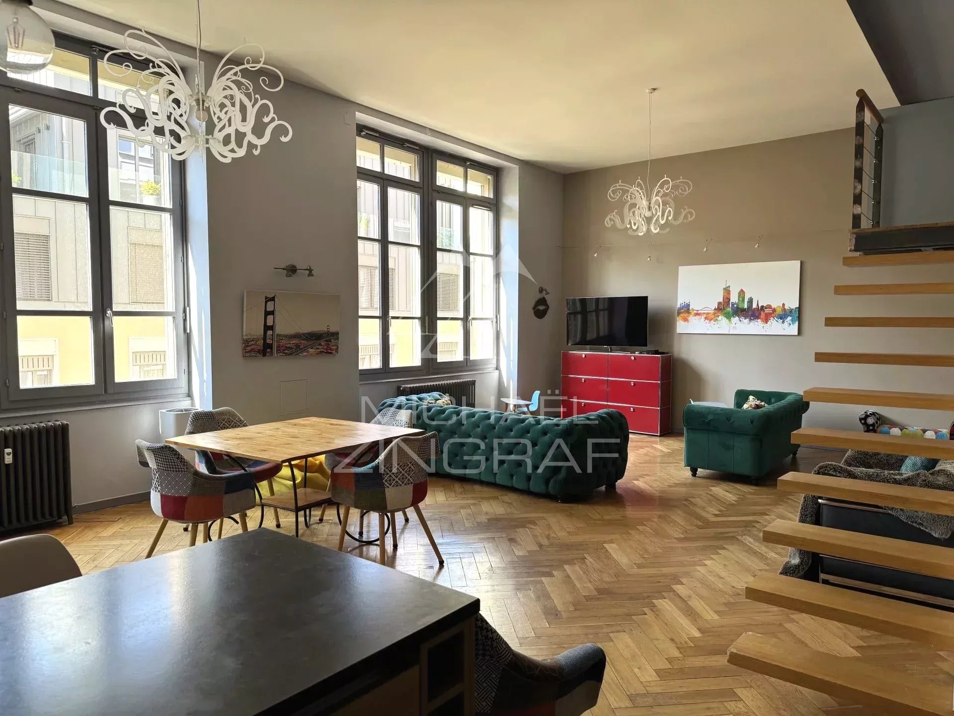 Interior of a renovated loft in Lyon 6th arrondissement, with a bright living room, modern furniture and high ceilings.