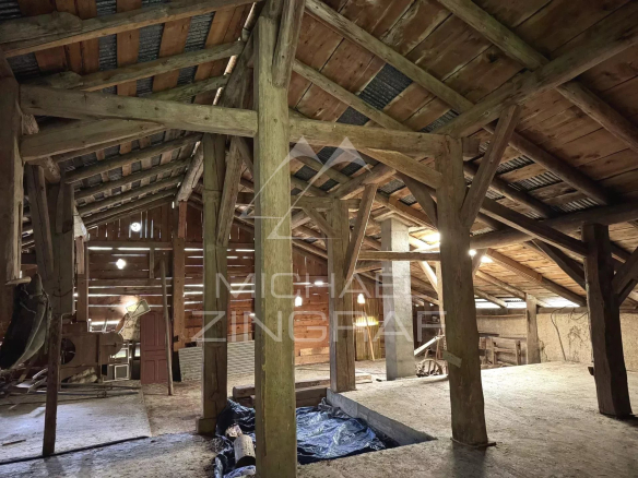 Interior of an old farmhouse to be renovated with wooden beams and cathedral-like space in Megève.