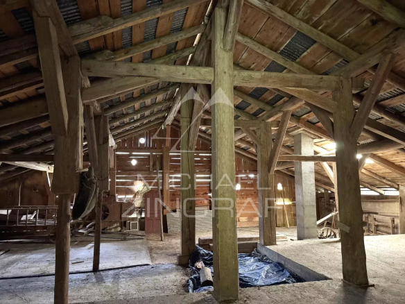 Interior of an old farmhouse to be renovated with wooden frame, view of the cathedral space.