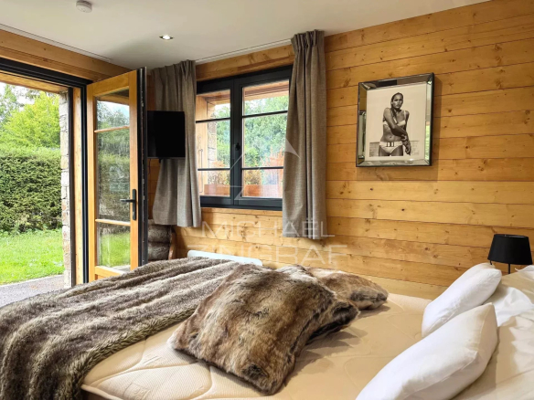 Room in a renovated chalet in Megève with wooden decor and a comfortable bed.
