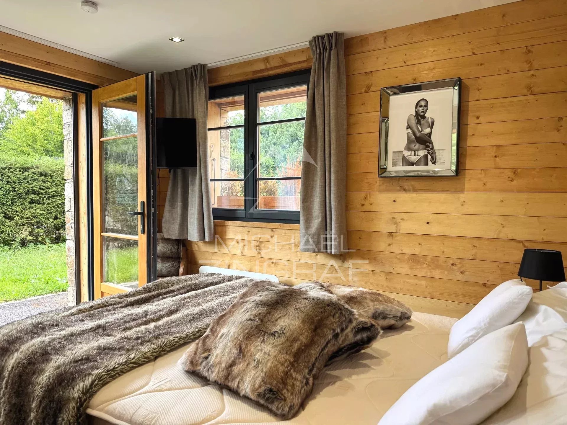Chalet room in Megève Room in a renovated chalet in Megève with wooden decor and a comfortable bed.