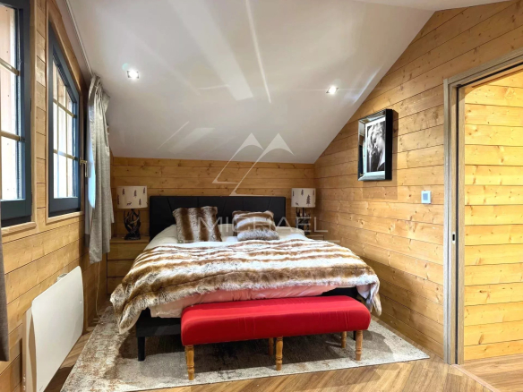 Room in a renovated chalet in Megève with double bed and wooden decor.