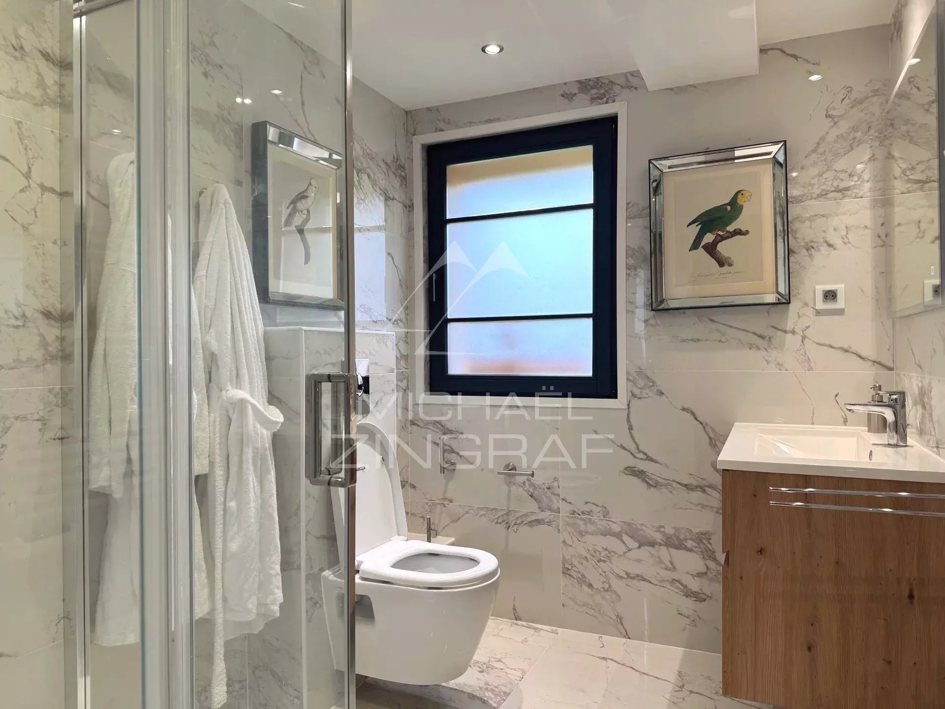 Bathroom of the renovated chalet in Megève Modern bathroom with glass shower and marble decor
