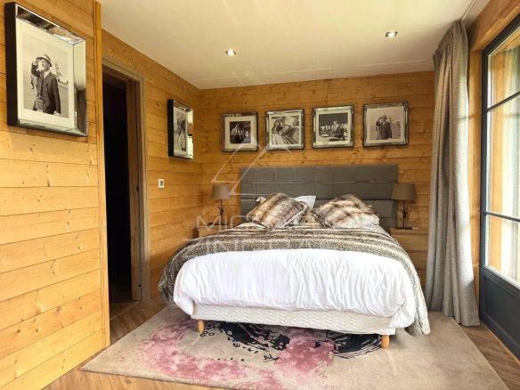 Room in a renovated chalet in Megève with wooden walls and a comfortable bed.
