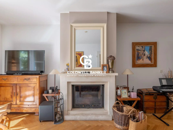 Cozy living room with a centered white fireplace, a large mirror above, and a wooden cabinet with a flat-screen TV to the left.