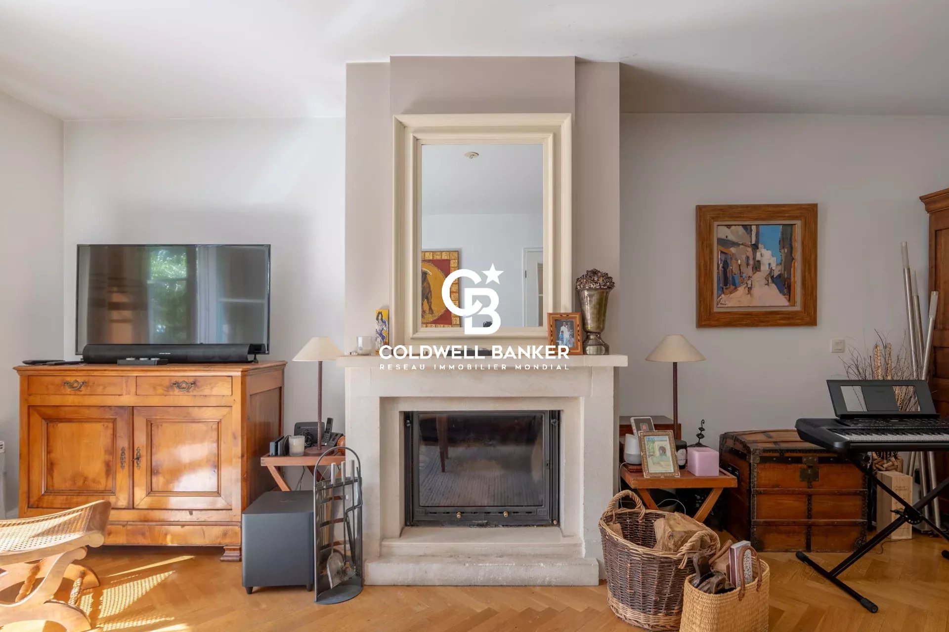 Cozy living room with a centered white fireplace, a large mirror above, and a wooden cabinet with a flat-screen TV to the left.