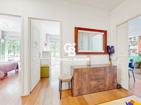 Bright white hallway with a rustic wooden sideboard and a large mirror, doors open to a bedroom and a living space.