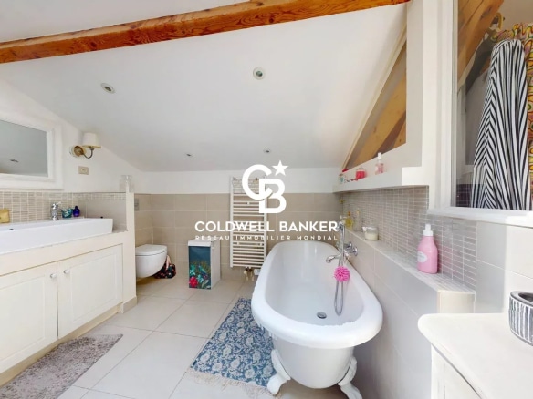 Salle de bain moderne avec baignoire sur pieds et carrelage clair dans une maison à Suresnes.