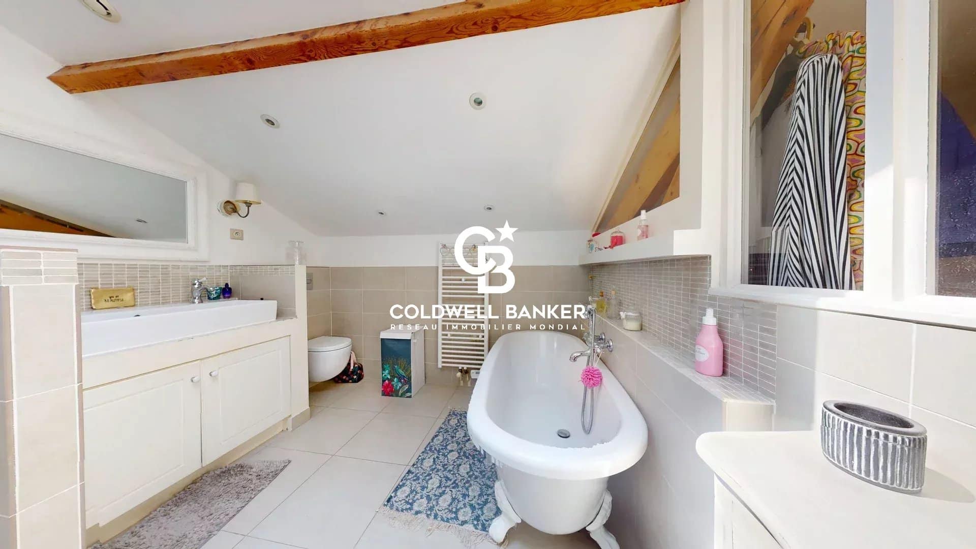 Salle de bain moderne avec baignoire sur pieds et carrelage clair dans une maison à Suresnes.