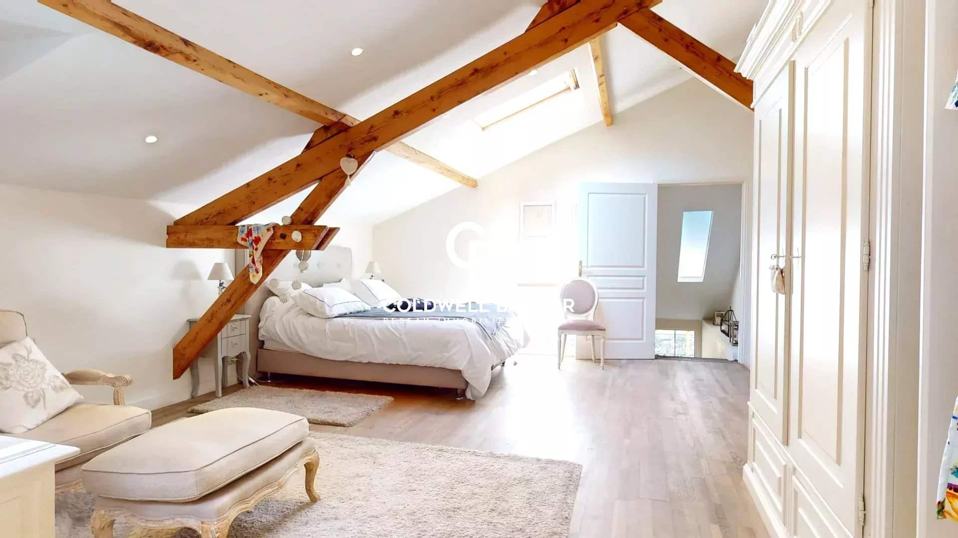 Chambre spacieuse avec poutres apparentes et lit double dans une maison à Suresnes.
