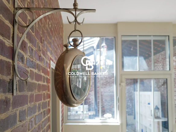 Antique clock hanging on a brick wall in a house in Suresnes.