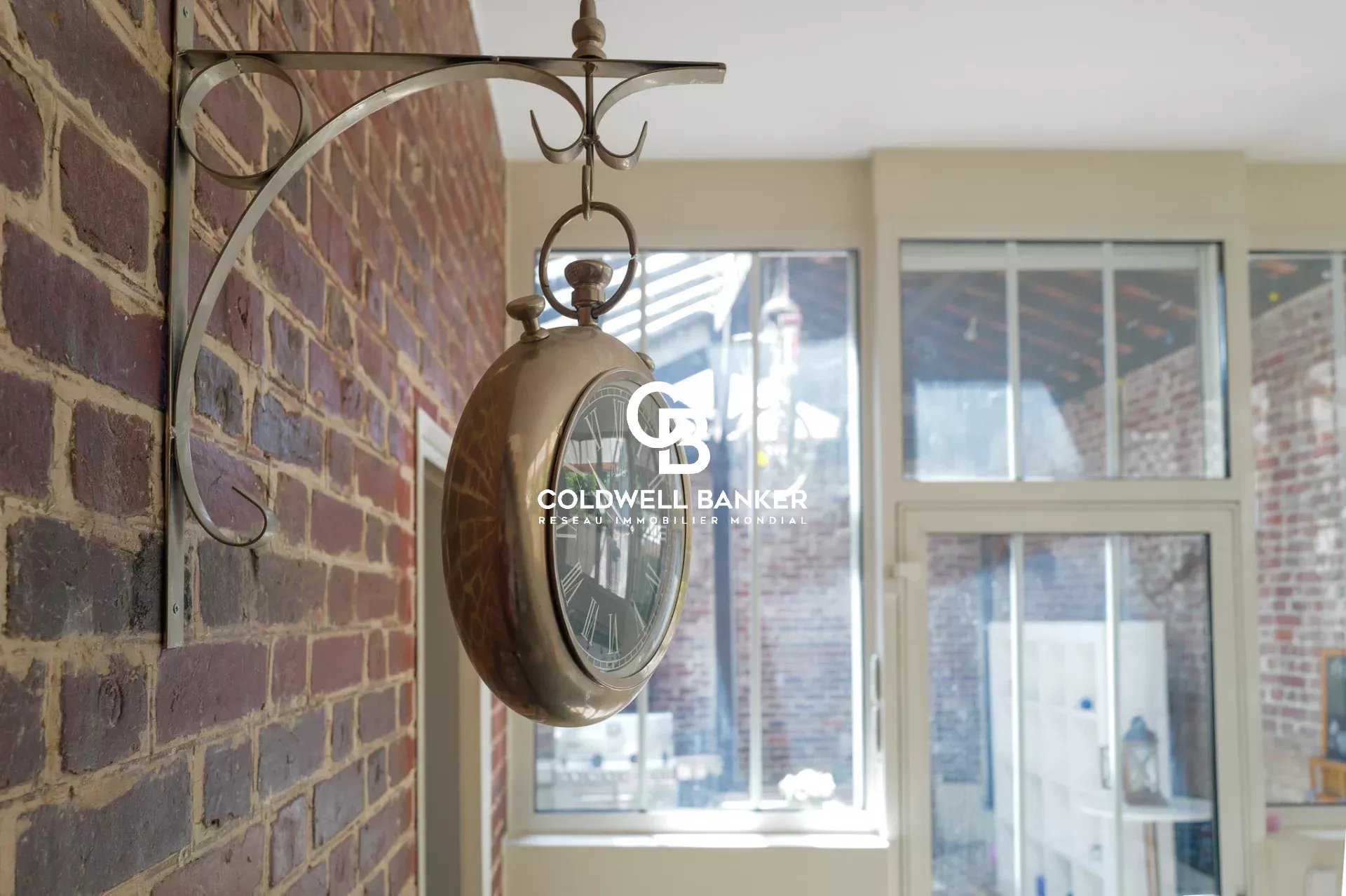Antique clock in a house in Suresnes Antique clock hanging on a brick wall in a house in Suresnes.