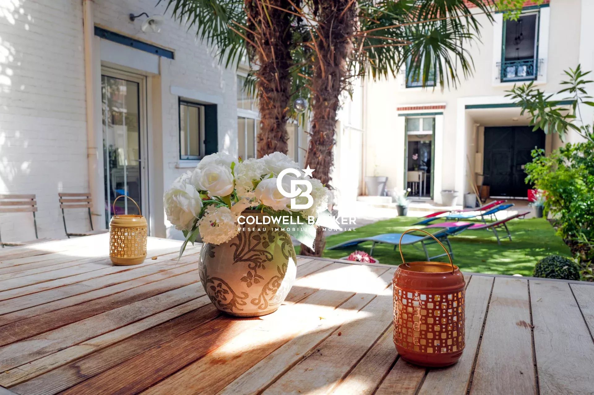 Terrace of a house in Suresnes Wooden terrace with vase of flowers and lanterns, surrounded by greenery in a house in Suresnes.
