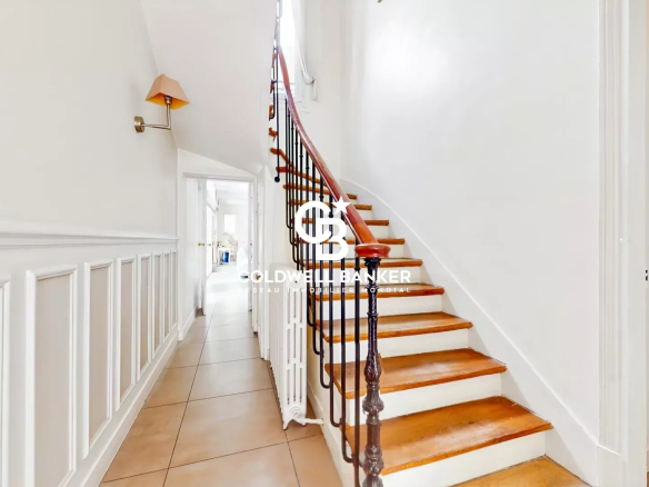 Interior of an old house with a wooden staircase and white walls in Suresnes.