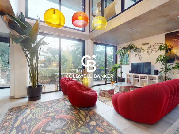 Intérieur d'une maison contemporaine avec un salon lumineux et des suspensions colorées.