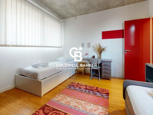 Chambre d'une maison contemporaine à Clamart avec deux lits, un bureau et un tapis coloré.