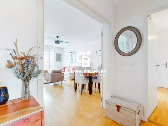 Entrée d'un appartement 4 pièces avec un salon visible au fond, décoré avec des meubles modernes.
