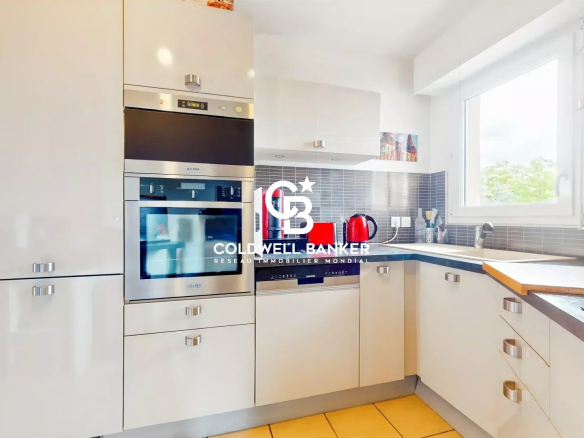 Cuisine moderne et lumineuse d'un appartement à Montrouge, avec des appareils électroménagers intégrés.