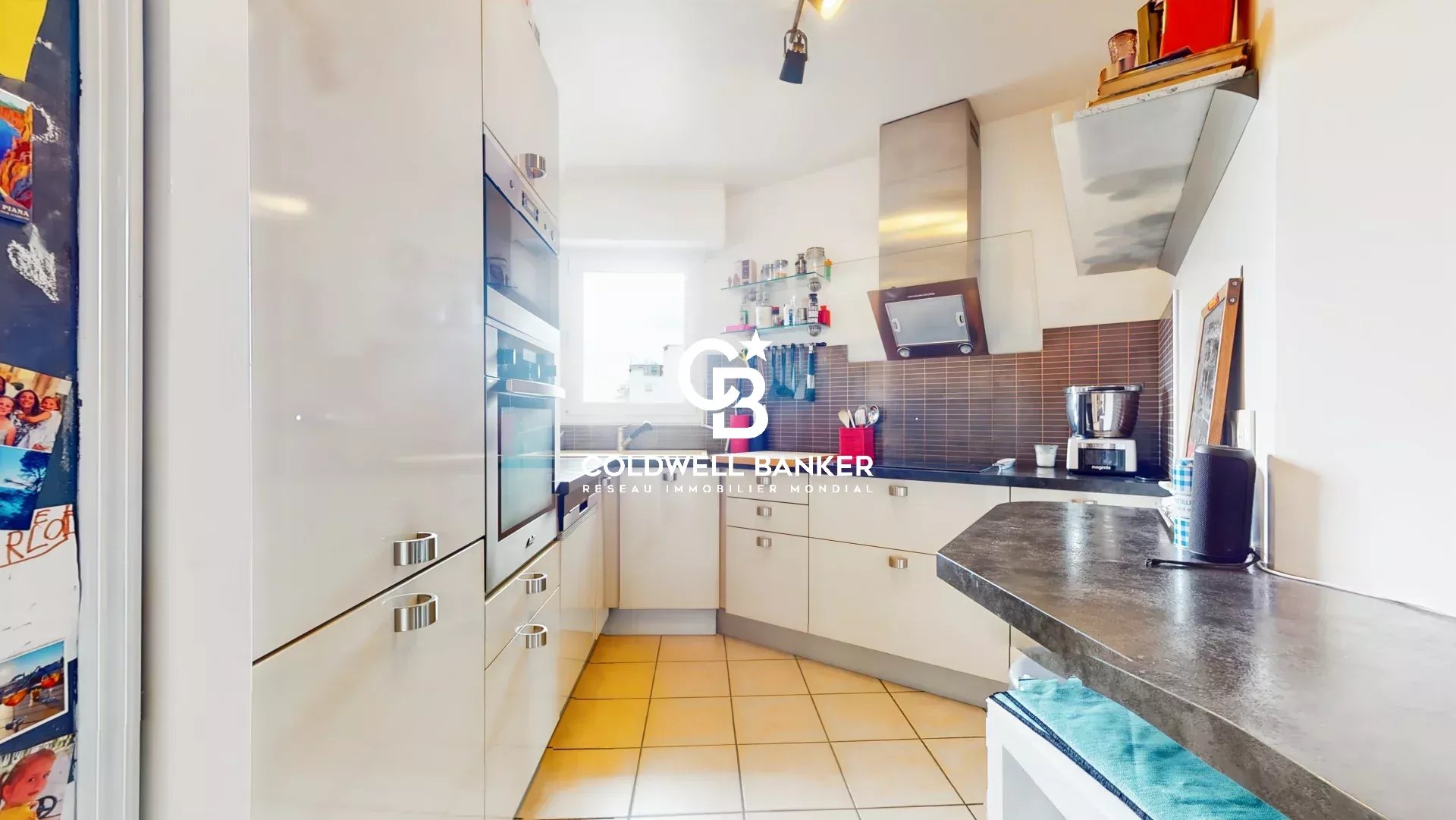 Cuisine d’un appartement à Montrouge Cuisine moderne d'un appartement de 4 pièces à Montrouge, avec des meubles blancs et un plan de travail en granit.
