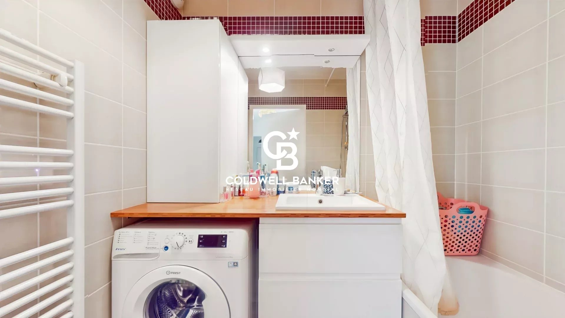 Salle de bain d’appartement à Montrouge Salle de bain d'un appartement avec machine à laver et lavabo.