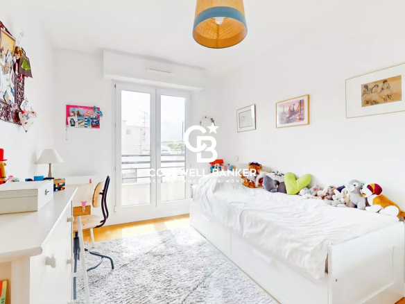Chambre d'un appartement à Montrouge, avec lit blanc et décor coloré.