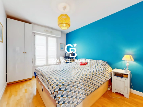 Chambre d'appartement avec mur bleu et lit double à Montrouge.