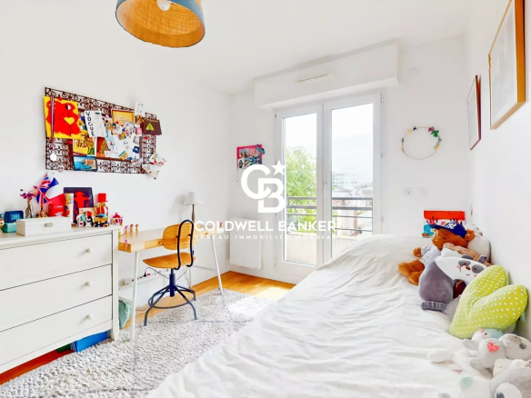 Chambre d'un appartement à Montrouge avec un lit, un bureau et des jouets.