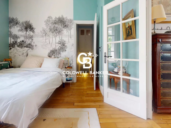 Chambre d'une maison familiale avec murs turquoise et lit, décorée de livres et de meubles en bois.