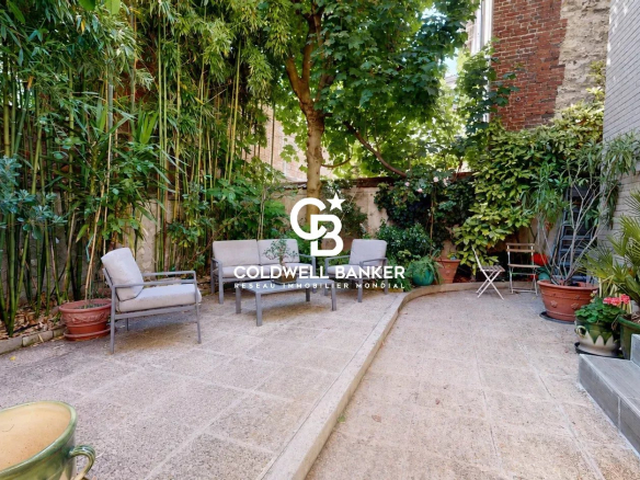 Jardin d'une maison familiale à Montrouge avec plantes et mobilier extérieur.