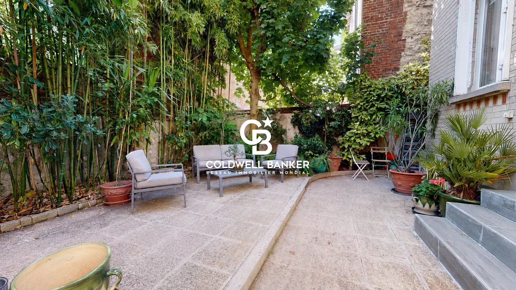 Jardin d'une maison familiale à Montrouge avec plantes et mobilier extérieur.