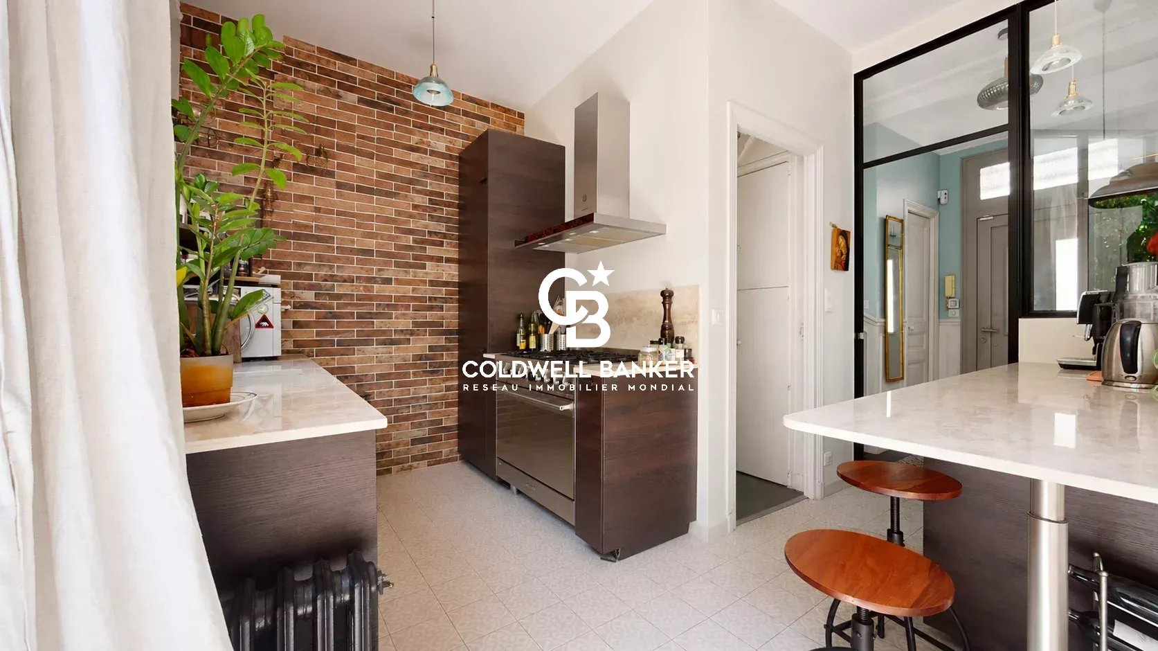 Cuisine moderne avec mur en briques et îlot central dans une maison familiale à Montrouge.