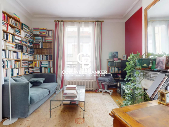 Intérieur d'une maison familiale avec un salon, des étagères remplies de livres et un canapé.