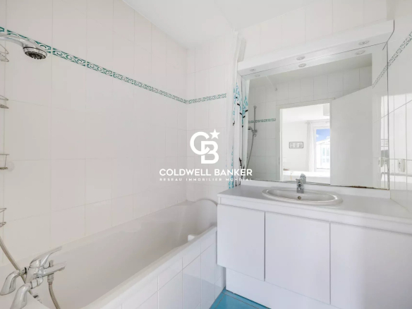 Bathroom with bathtub and mirror, white tiled walls.