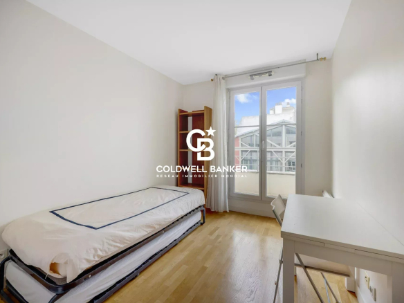 Apartment room in Montrouge with bed and desk, window overlooking the outside.
