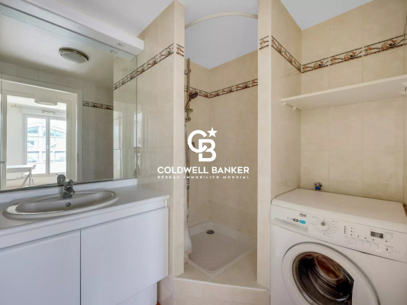 Bathroom with shower, sink and washing machine in a modern apartment.