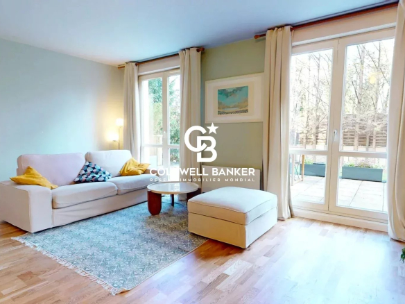 Salon lumineux d'un appartement avec canapé et accès à une terrasse.